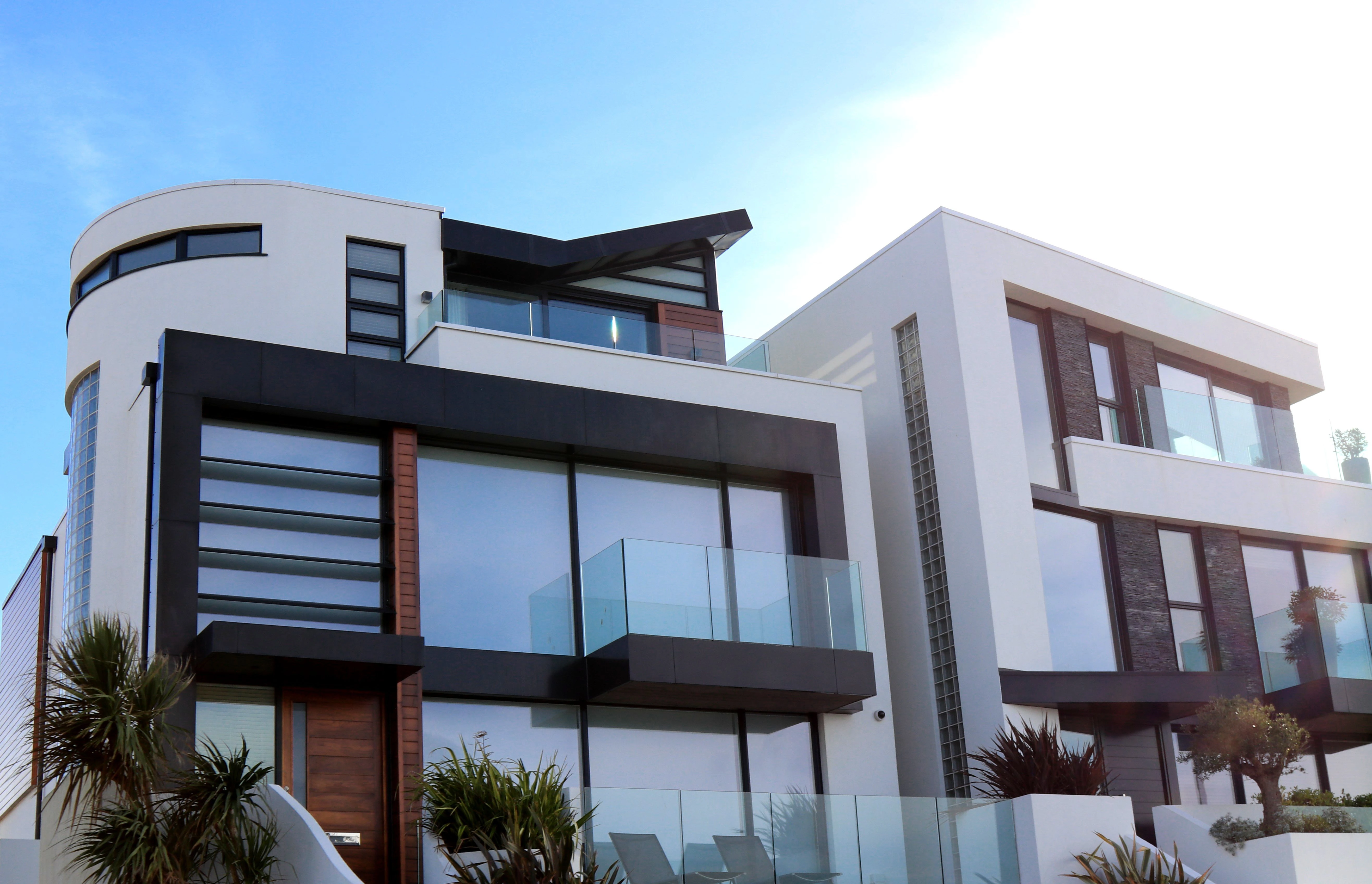 Vivienda contemporánea con ventanales amplios y balcones de vidrio, referencia arquitectónica